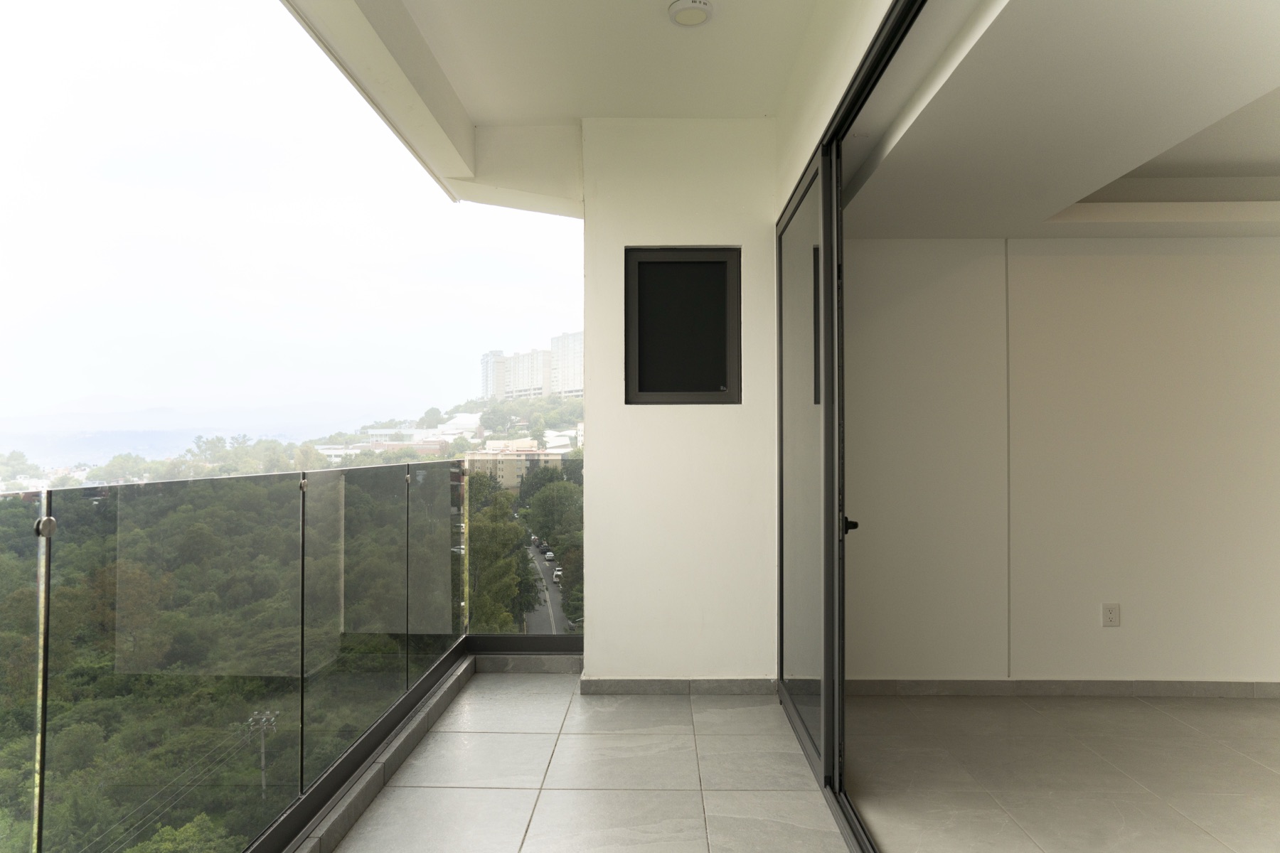 Terraza con barandal de cristal y vista a la ciudad